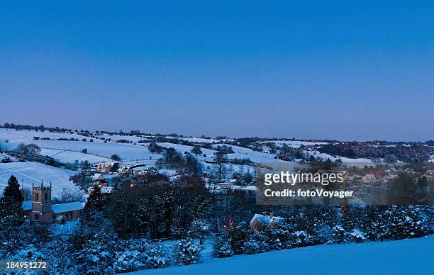 warm lights glowing idyllic winter village - village stock pictures, royalty-free photos & images