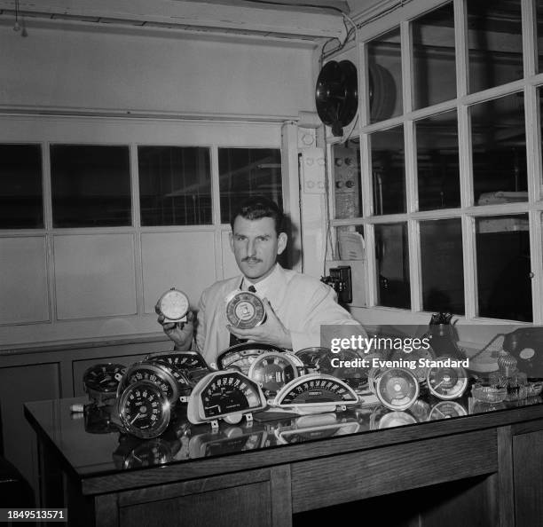 George Dickinson of Smith's Motor Accessories factory, seated at a desk with a collection of odometers, Cricklewood, London, March 19th 1956.