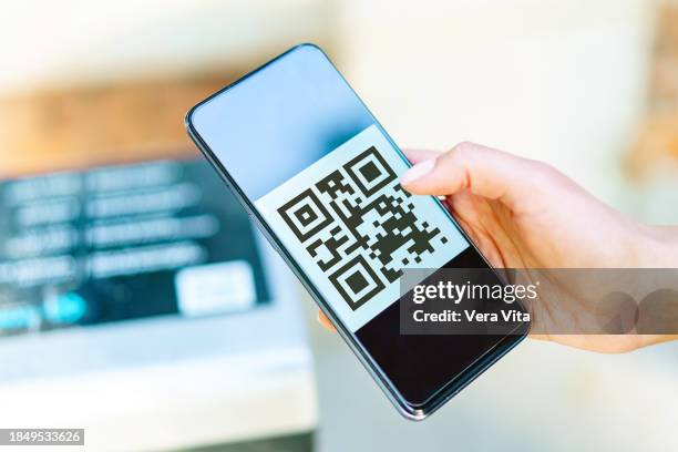 close up view of woman hand scanning with smartphone screen a digital qr code - lector de código de barras fotografías e imágenes de stock