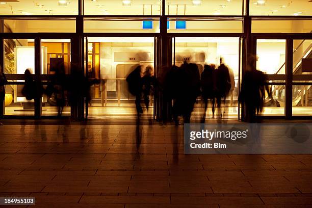 people entering modern building at evening - entering shop stock pictures, royalty-free photos & images
