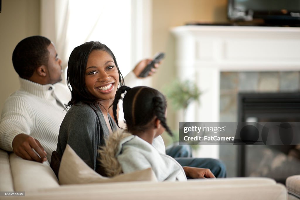 Smiling family on couch watching television