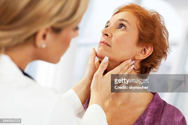 female doctor examining her patient. - throat stock pictures, royalty-free photos & images