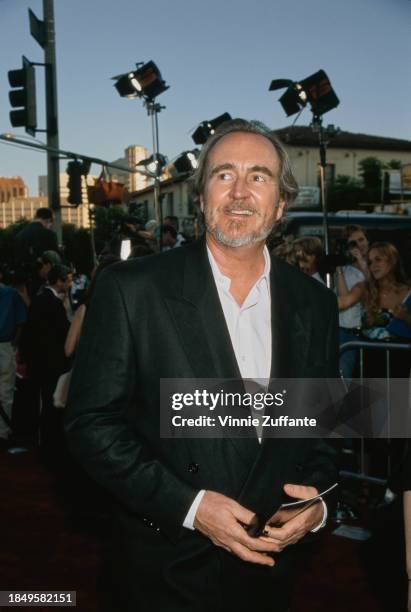 American film director and screenwriter Wes Craven, wearing a black jacket over a white shirt, attends the Westwood premiere of 'Halloween H20: 20...