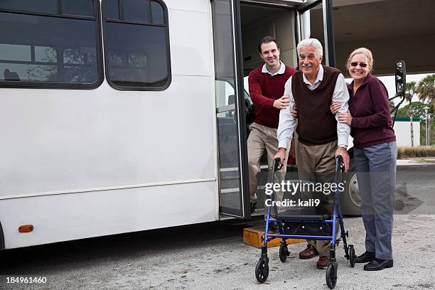 man helping senior couple outside shuttle bus - senior public transportation stock pictures, royalty-free photos & images