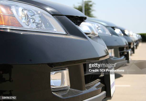 row of brand newblack sedans parked at a car lot - bumper 個照片及圖片檔