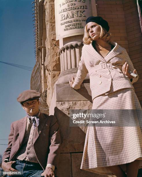 Faye Dunaway and Michael J Pollard as robbers posing outside bank from 1967 'Bonnie and Clyde'.