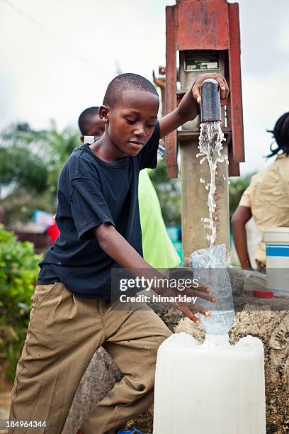 african boy de bomba de agua - niño-tomando-agua fotografías e imágenes de stock