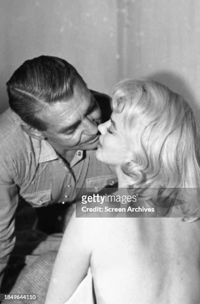 Clark Gable kisses a bare-backed Marilyn Monroe in a scene from the 1961 John Huston film 'The Misfits'.