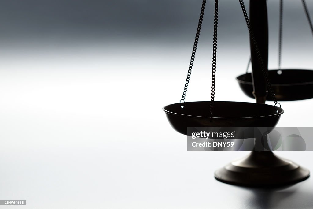 Lone justice scale on simple gray background