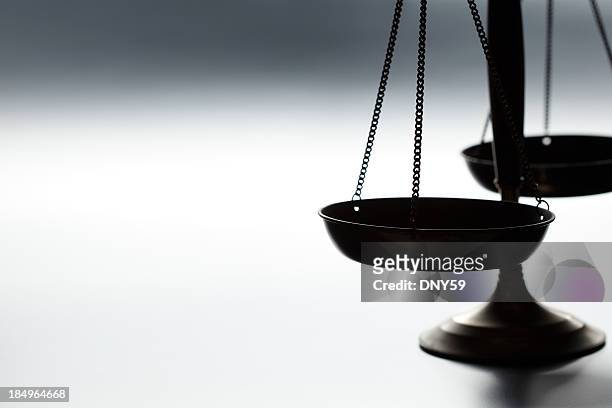 lone justice scale on simple gray background - gerechtigheid stockfoto's en -beelden