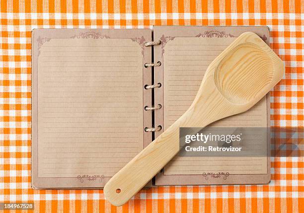 wooden spoon and old notebook on orange tableclot - blank pages in open book overhead view stock pictures, royalty-free photos & images