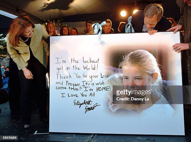 Elizabeth Smart's parents Lois and Ed Smart look at a card with a message from Elizabeth during a celebration at Liberty Park March 14, 2003 in Salt...