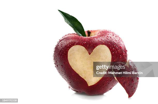 water on red apple with heart shape - red delicious stockfoto's en -beelden