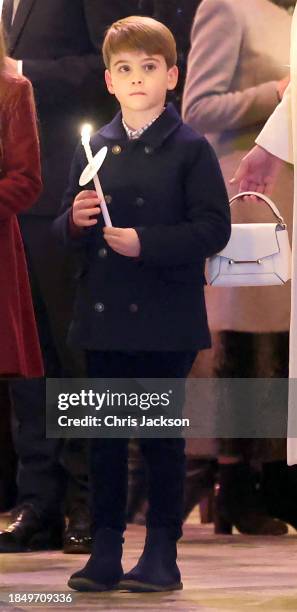 Prince Louis of Wales holds a candle as he leaves with h family at The "Together At Christmas" Carol Service at Westminster Abbey on December 08,...