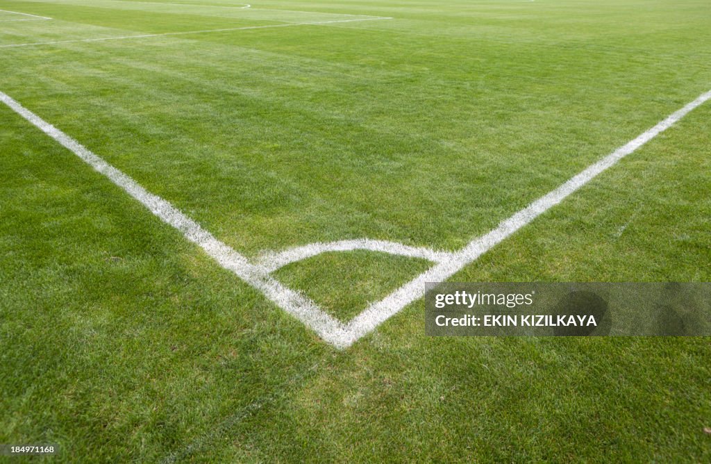 Campo de Futebol verde relva com canto branco com linhas