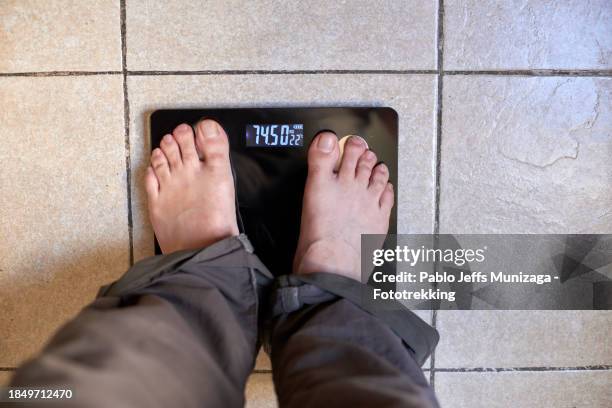 adult feet on scale - größenunterschied stock-fotos und bilder