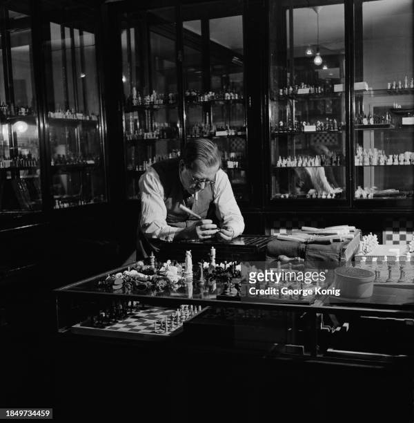 British antique dealer Alexander Hammond repairing a chess piece in his London shop, December 1948. Hammond owned a collection of 12,000 chess pieces...