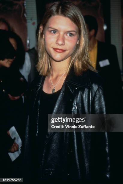 American actress Claire Danes, wearing a black leather jacket over a black scoop neck top, attends the Hollywood premiere of 'The Craft', held at...