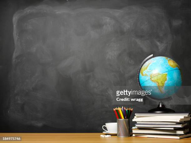 world globe on books on school teacher's desk - classroom desk stock pictures, royalty-free photos & images