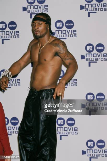American singer and songwriter D'Angelo, shirtless with a black headband and black trousers, in the press room of the 2000 MTV Movie Awards, held at...