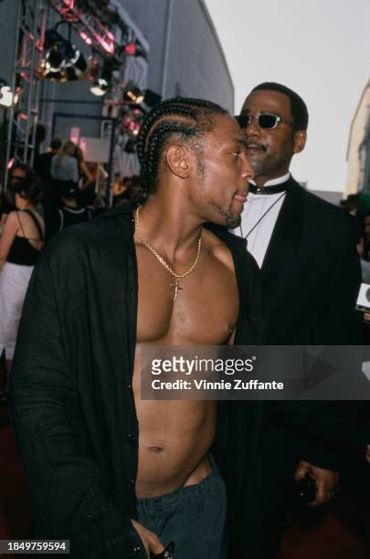 American singer and songwriter D'Angelo, wearing an open black shirt with his chest exposed, attends the 2000 MTV Movie Awards, held at Sony Pictures...