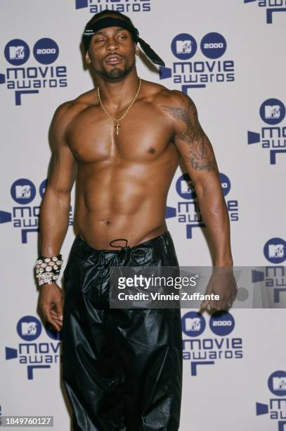 American singer and songwriter D'Angelo, shirtless with a black headband and black trousers, in the press room of the 2000 MTV Movie Awards, held at...