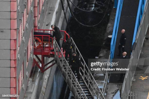 Police officers walk down the steps of the Bibby Stockholm Barge as a body is brought out on a gurney on December 12, 2023 in Portland, England....