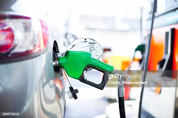 a close-up of a car being filled with gas - brandstofpomp stockfoto's en -beelden