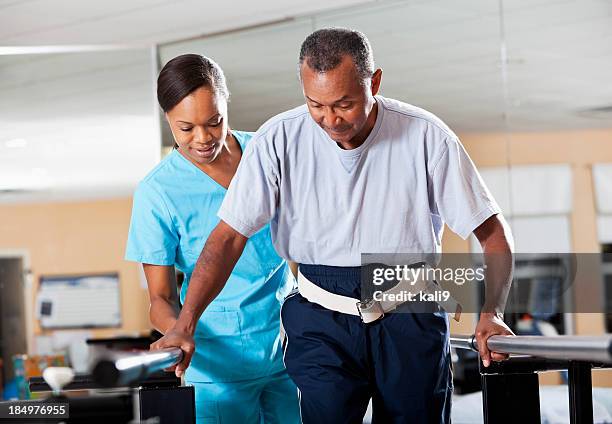 terapeuta y paciente haciendo marcha de la capacitación - african american man helping elderly fotografías e imágenes de stock