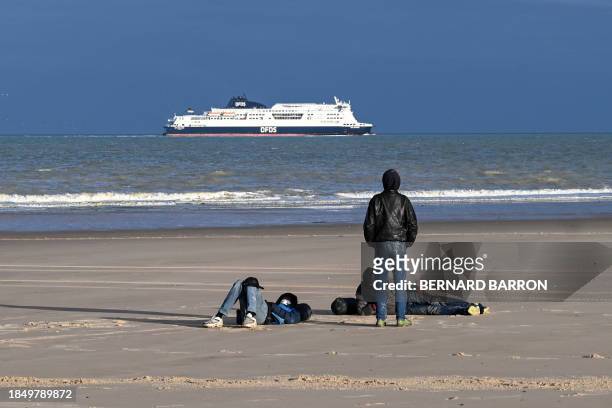 Migrants gather on a beach after they failed to illegally cross the English Channel to reach Britain, in Sangatte, northern France, on December 15,...
