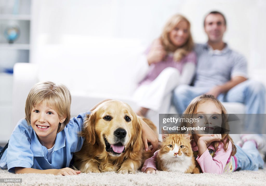Alegre familia y sus animales domésticos en su hogar.