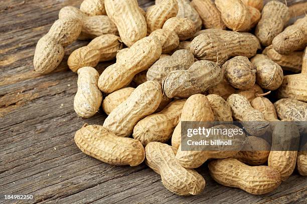 roasted peanuts in shell on old rustic table - peanuts stock pictures, royalty-free photos & images