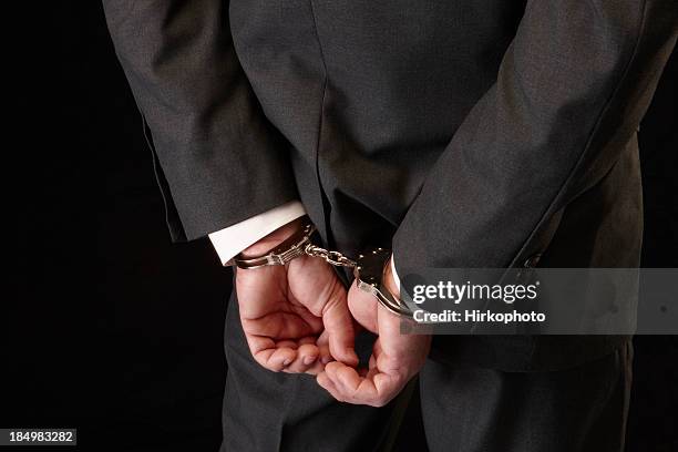 wirtschaftskriminalität - handcuffs stock-fotos und bilder