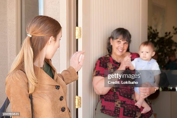 young mom leaves baby with sitter - nanny stock pictures, royalty-free photos & images