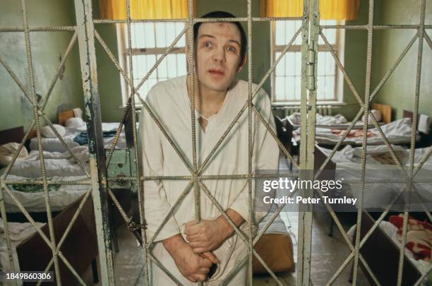 Patient stands behind his room bars in a psychiatric hospital in Moscow, Russia, 19th February 1992.