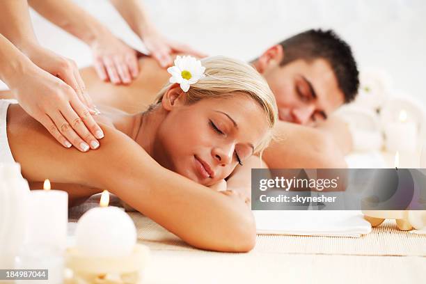 beautiful couple enjoying in the back massage. - massage couple stock pictures, royalty-free photos & images