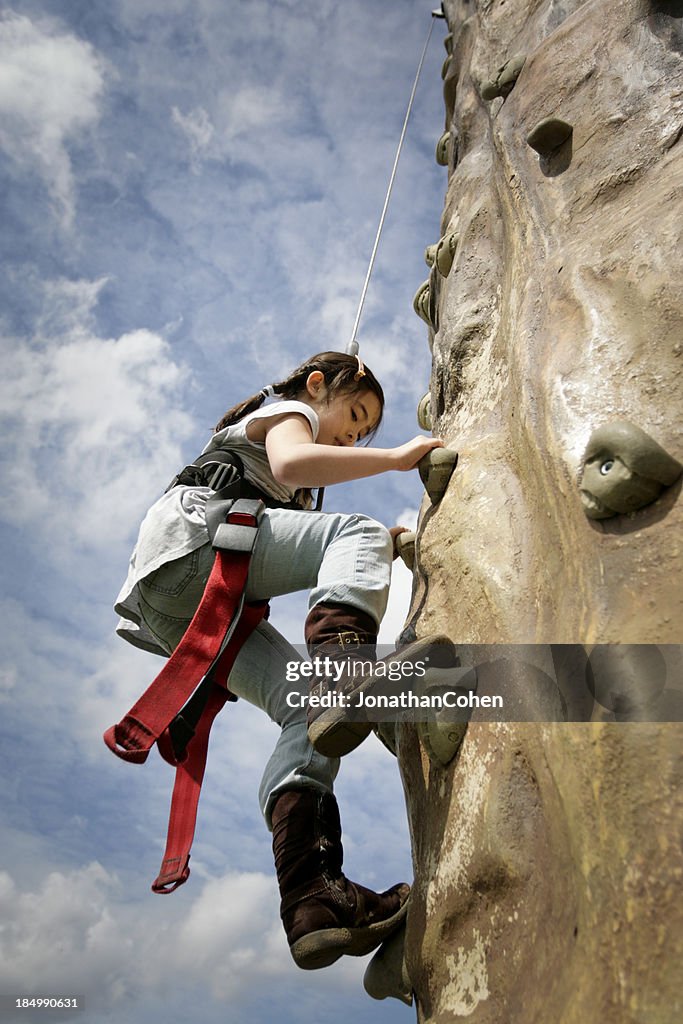 Young Girl Climbing de la pared de rocas