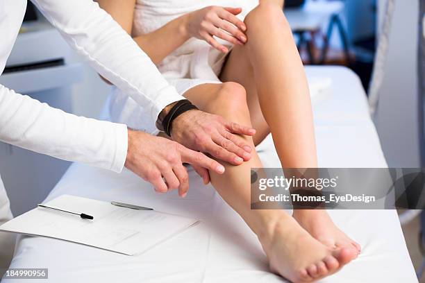 patient showing cosmetologist problem area on her leg - man waxing legs stockfoto's en -beelden
