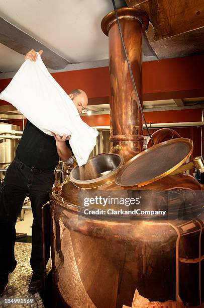 brewer adding malt to a copper mash tun or kettle - fermentation tank stock pictures, royalty-free photos & images