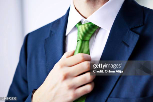 uomo d'affari cravatta di regolazione - green suit foto e immagini stock