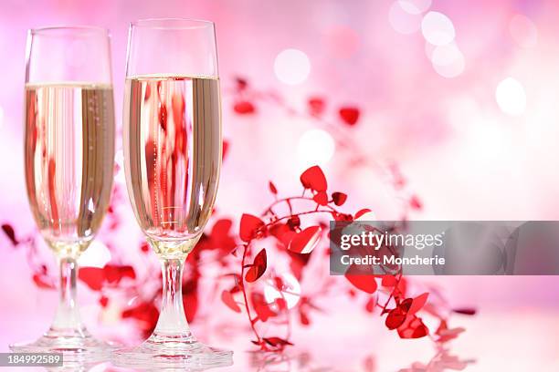 champagne flutes on illuminated background - pink champagne stock pictures, royalty-free photos & images