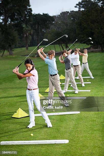 group of children on golf driving range - golf lessons stock pictures, royalty-free photos & images