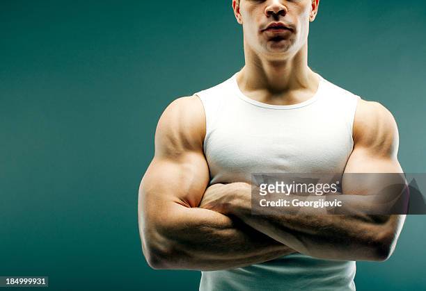 starker mann mit überkreuzten armen - torso stock-fotos und bilder