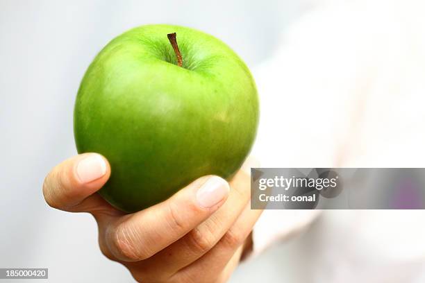 green apple en mano - manzana verde fotografías e imágenes de stock