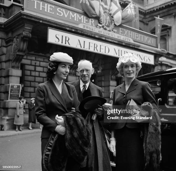 Artist Sir William Russell Flint with businesswoman Enid Chanelle, right, and her sister Mavis Cooper, attending an exhibition of paintings at the...