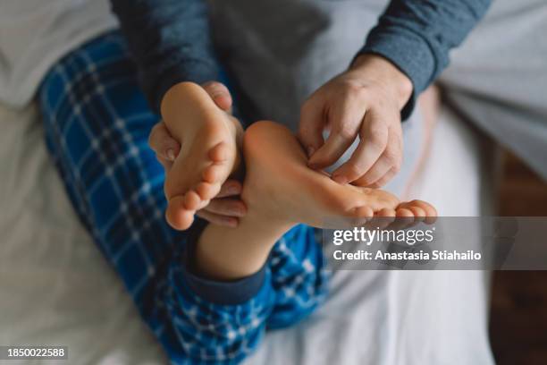 kid's feet under  blanket with father's hand tickling. - tickling feet - fotografias e filmes do acervo