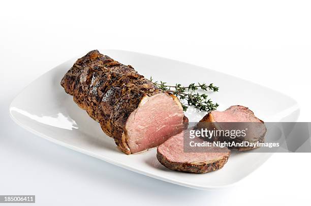 cooked roast beef on a white plate - beef stock pictures, royalty-free photos & images