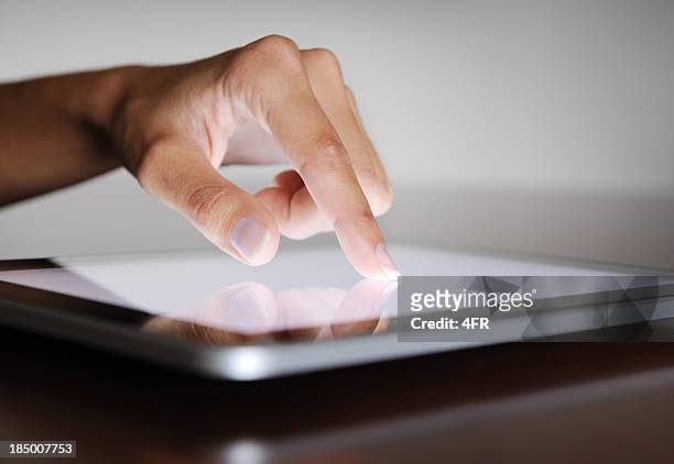 dedo apuntando sobre una tableta digital - swipe card fotografías e imágenes de stock