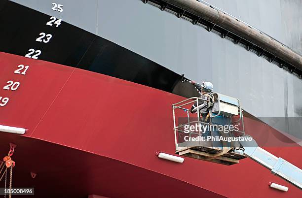 man painting ship's hull with roller - ship stock pictures, royalty-free photos & images