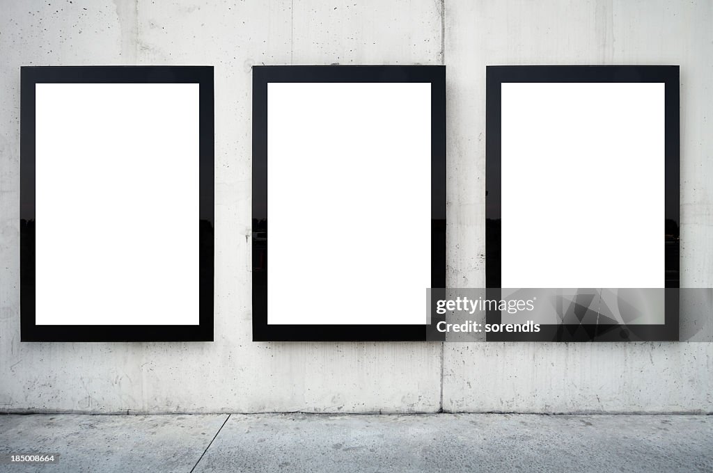 Three blank billboards on wall.
